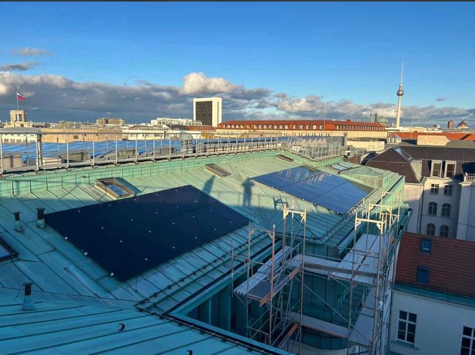 Dachansicht des Bundesministeriums für Ernährung und Landwirtschaft in Berlin mit Photovoltaik auf patiniertem Kupferdach und Fernsehturm im Hintergrund