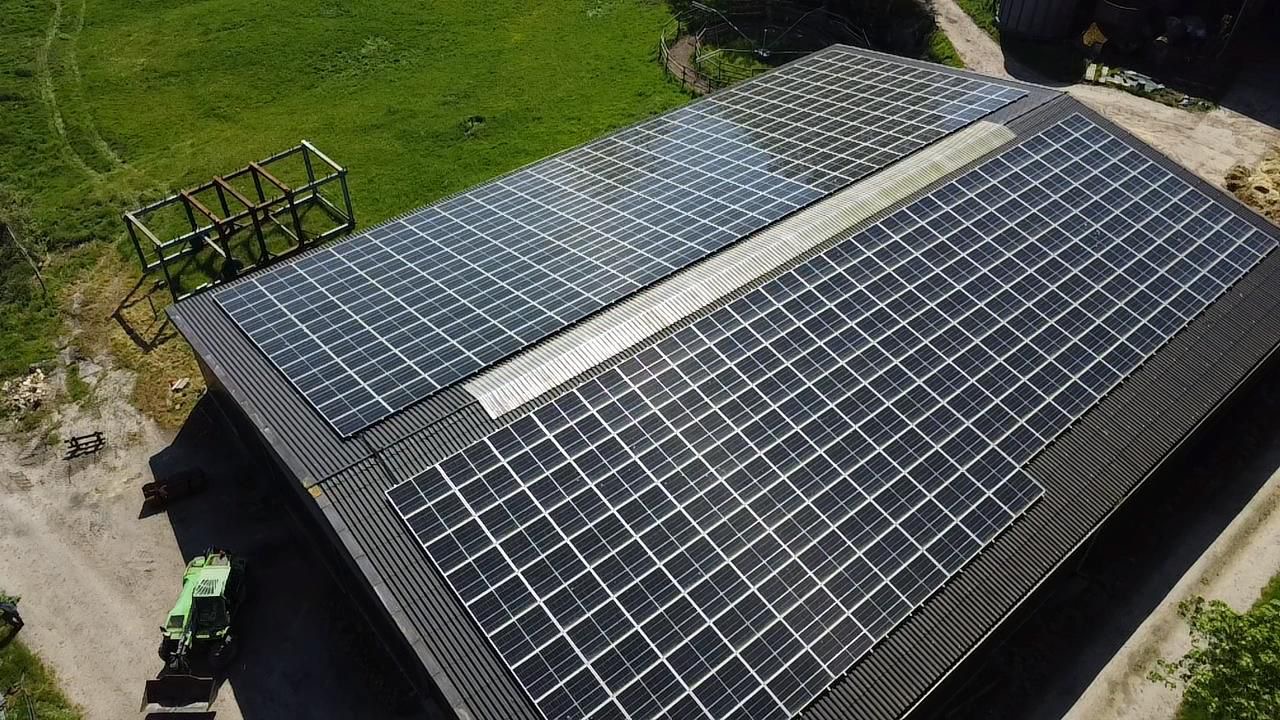 Luftaufnahme einer landwirtschaftlichen Halle mit großflächiger Solaranlage