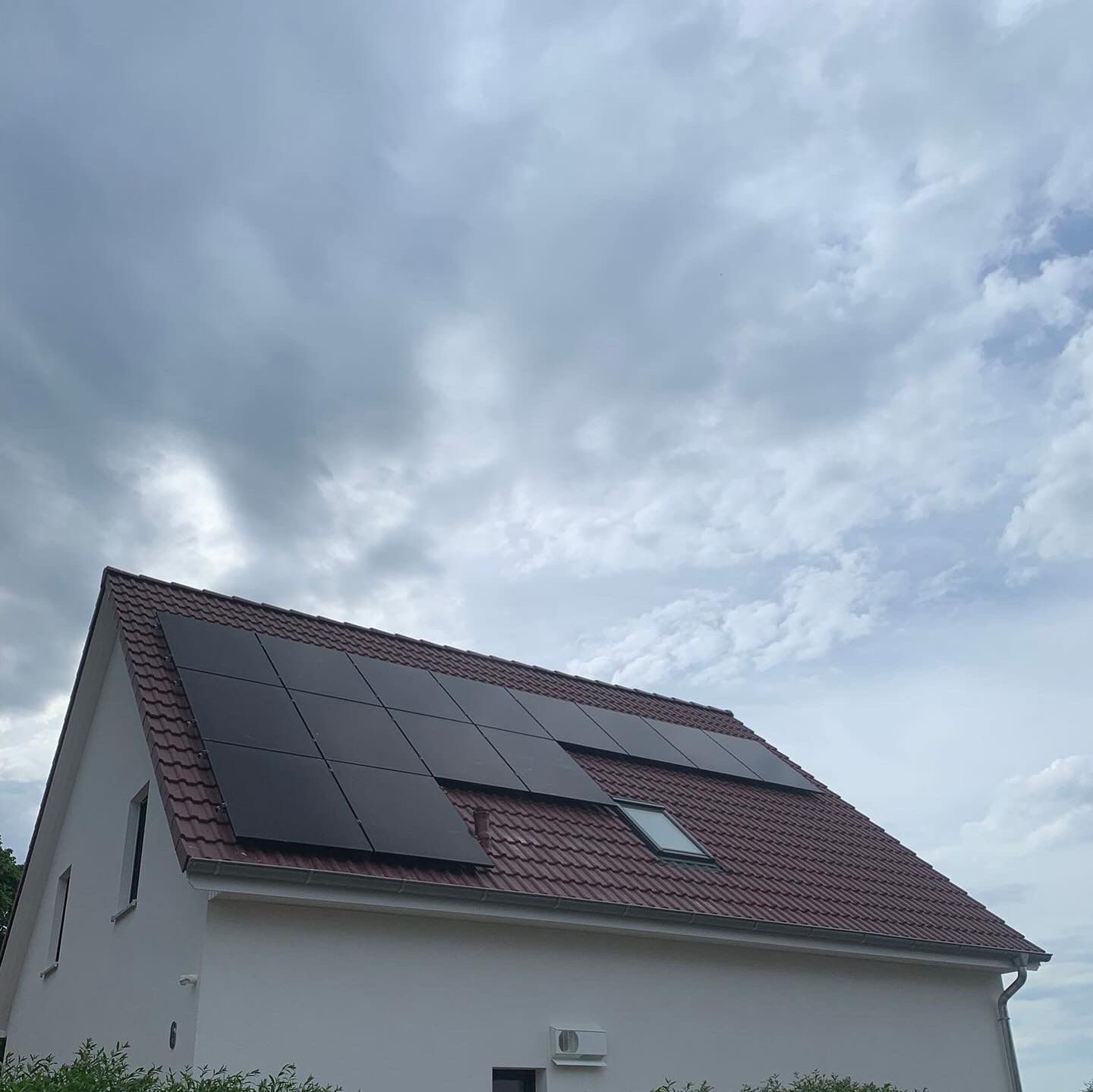 Einfamilienhaus mit rotem Dach und schwarzen Solarmodulen
