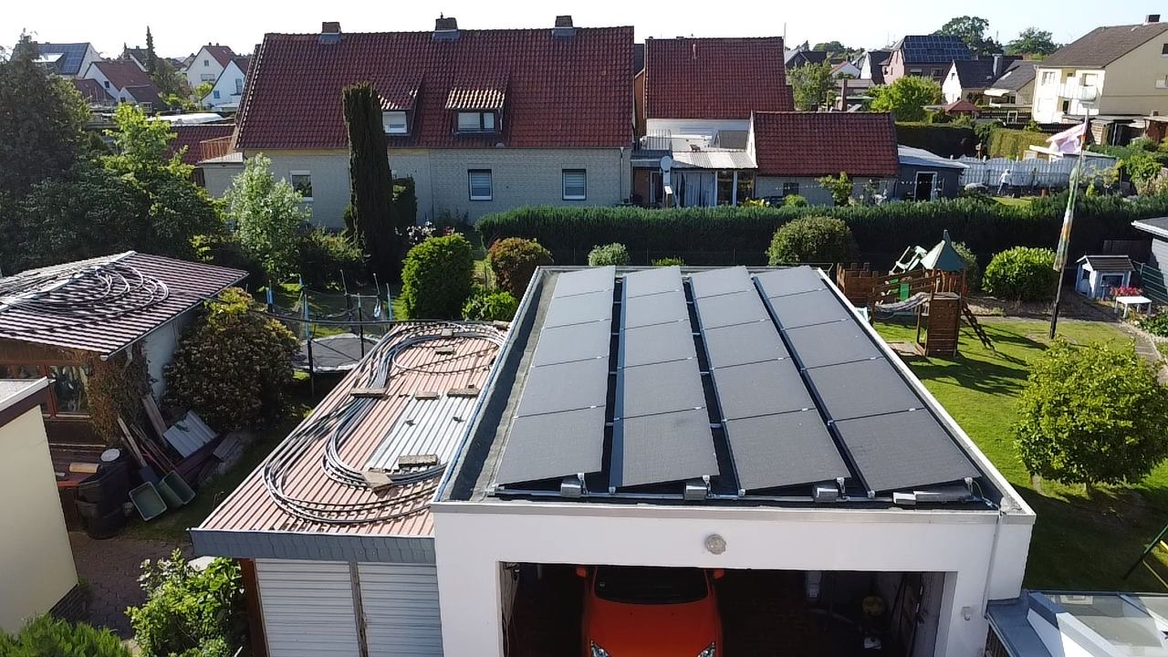 Luftaufnahme eines Garagenflachdachs mit aufgeständerten Solarmodulen